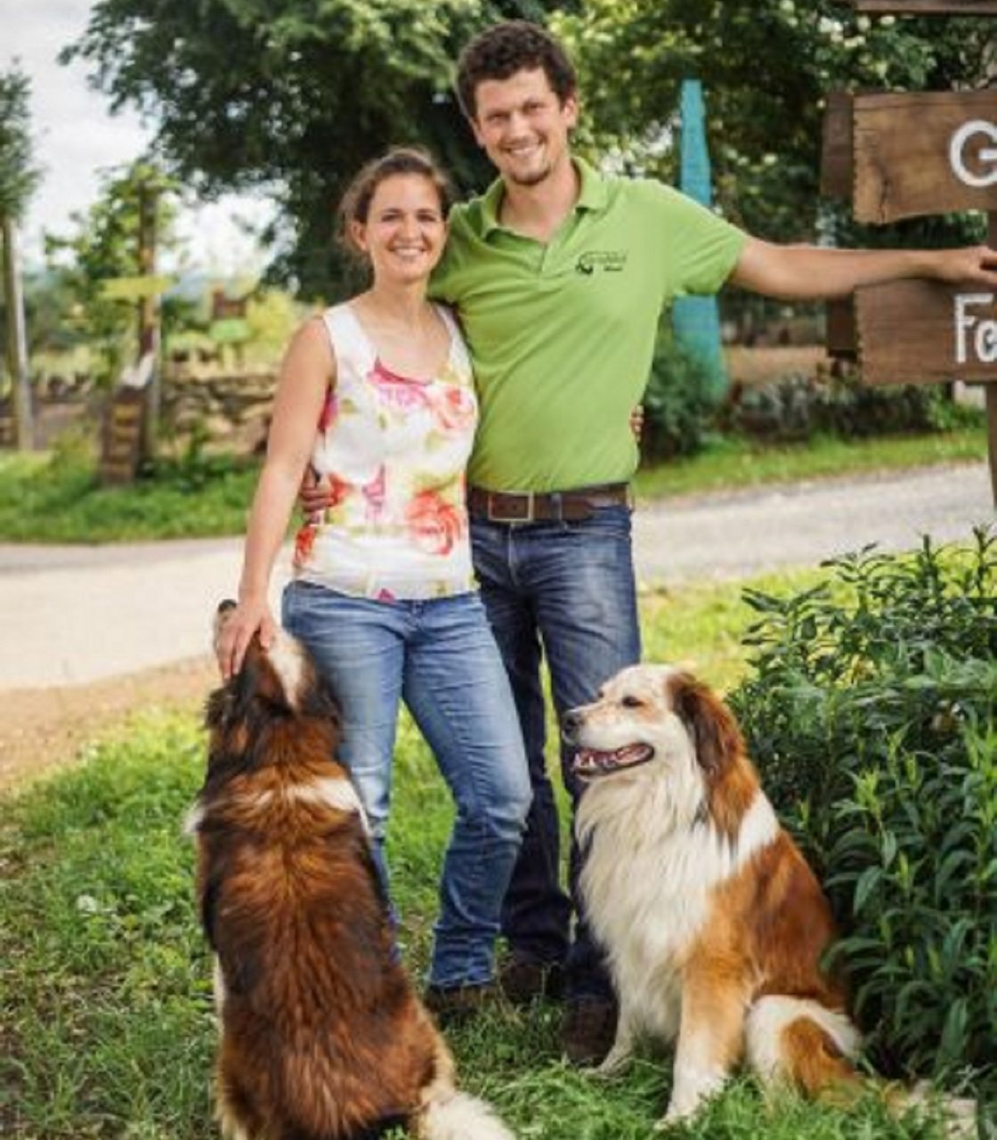 Michaela und Alexander Balk mit ihren Hunden neben dem Willkommensschild des Grießlhofs. Bild: Neustadt NEW