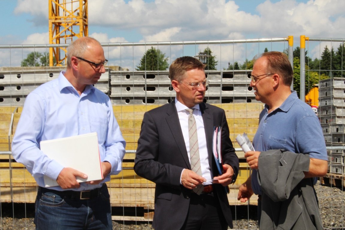 Harald Schaller, Projektsteuerung, Betriebwirt (VWA), MdL Tobias Reiß und Bauleiter Harald Scharnagl vor der E-House-Baustelle auf dem Campus der OTH in Weiden.