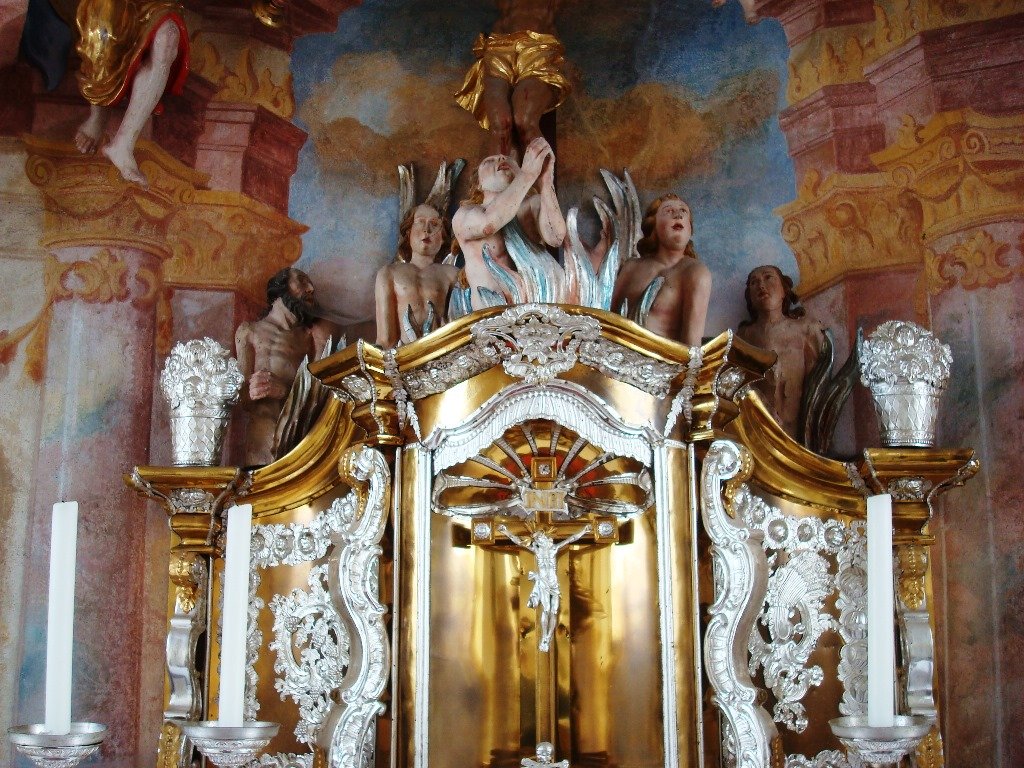 Über dem Altar sind Figuren zu sehen, die ins Höllenfeuer gekommen sind und offenbar um Gnade flehen.