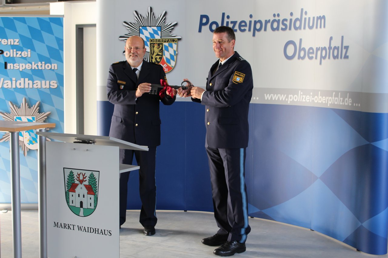 Polizeipräsident Norbert Zink (links) übergibt das Gebäude feierlich an den Ersten Polizeihauptkommissar Stefan Moller (rechts). Bild: Grenzpolizeiinspektion Waidhaus