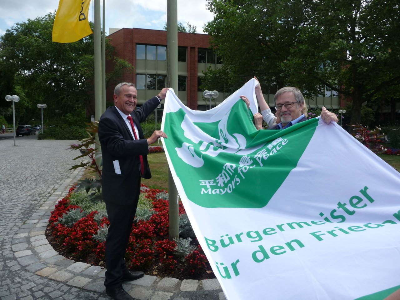 OB Kurt Seggewiß hisst die Flagge der vereinigung "Mayors for Peace"