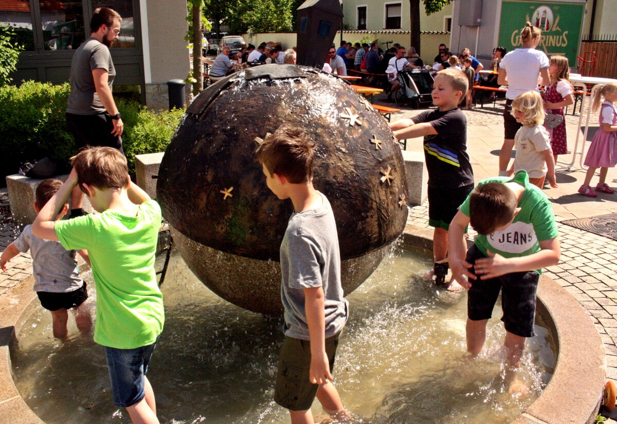 Kinder waten im Gemeindebrunnen. Foto: Reinhard Kreuzer