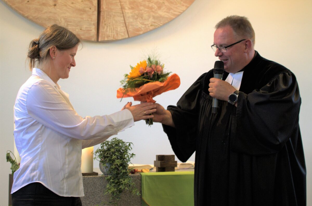 Pfarrer Thomas Berthold (rechts) bedankte sich bei Pfarrerin Anne Utz (links) für ihre tatkräftige Mitarbeit in der Kita mit einem Blumenstrauß. Bild. Renate Gradl