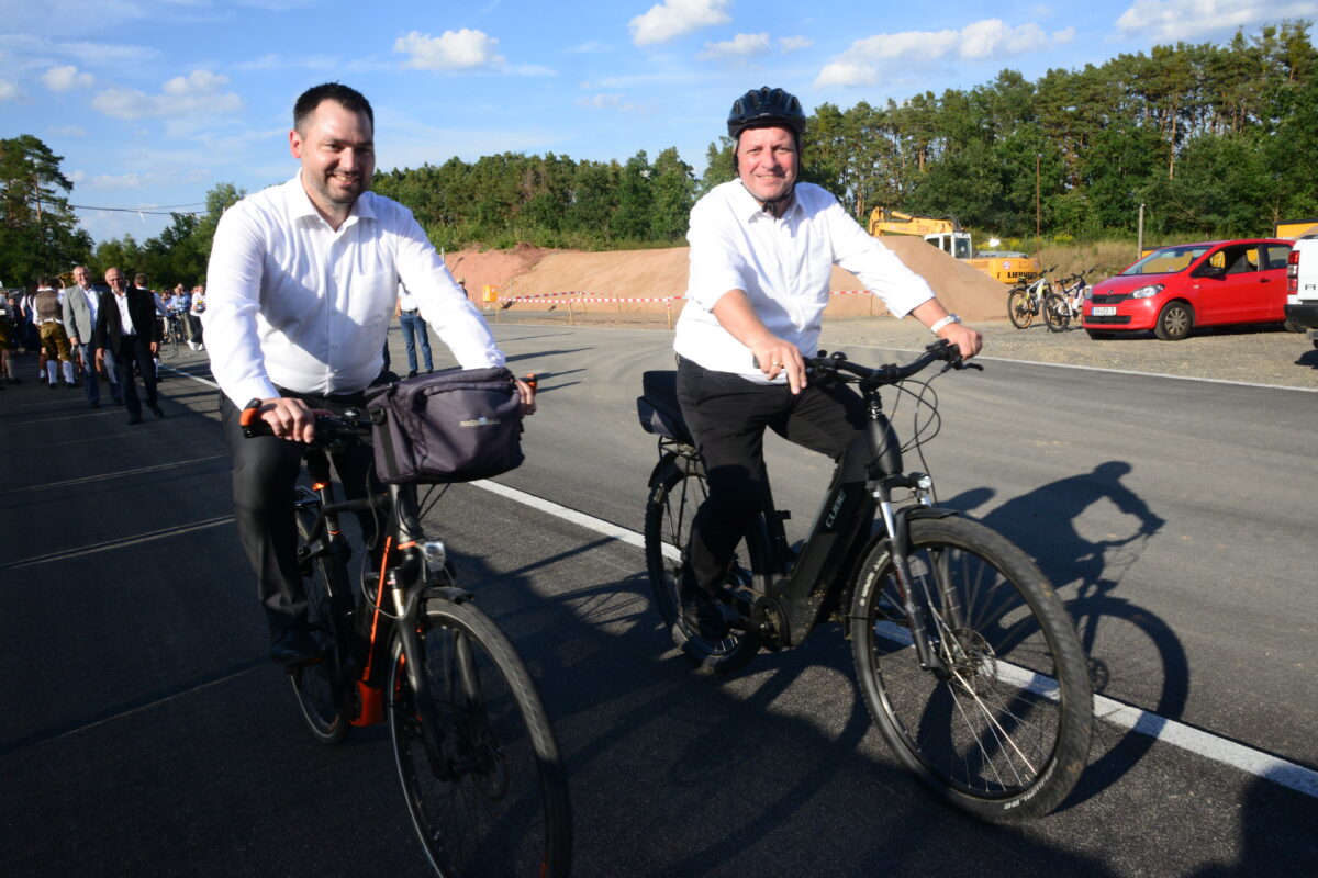 Bürgermeister Sebastian Hartl (links) und Staatsminister Christian
Bernreiter fahren gemeinsam den neuen Radweg bis zur BAB A 93 und wieder
zurück. Bild: Walter Beyerlein