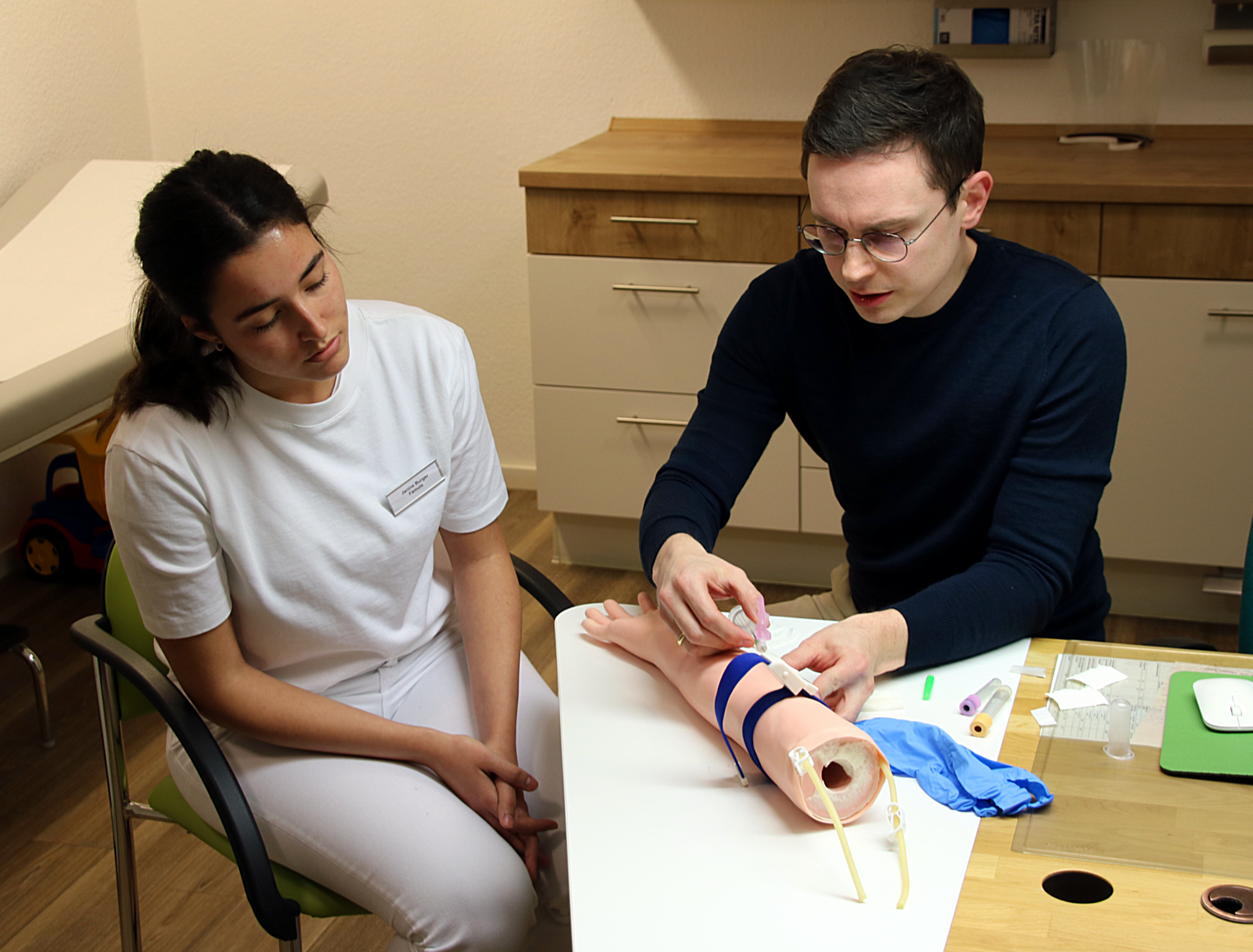 Die Medizinstudentin Janine Burger (links) und Dr. Luca Frank beim Blutabnehmen am Übungsarm. Foto: Landratsamt Tirschenreuth, Fabian Polster