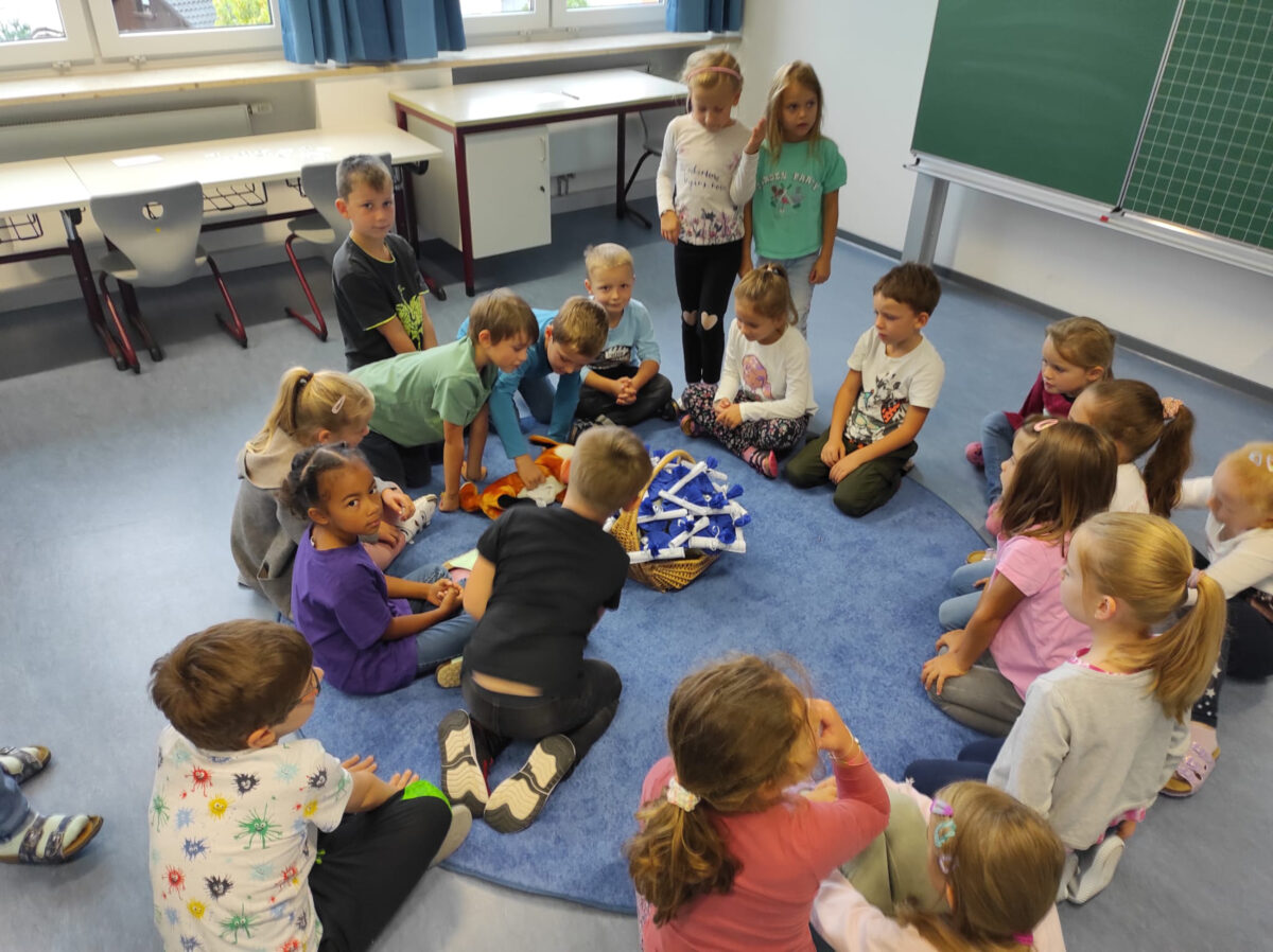 Der Büchereifuchs übrgibt an die Mädchen und Buben der 1. Klasse kleine Schultüten. Foto: Cornelia Greiner-Braun