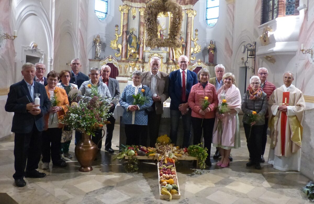 Die Jubelpaare und der Pfarrer stellten sich zum Gruppenfoto hinter dem Erntedankkreuz zum Erinnerungsfoto. Foto: Hans Meißner