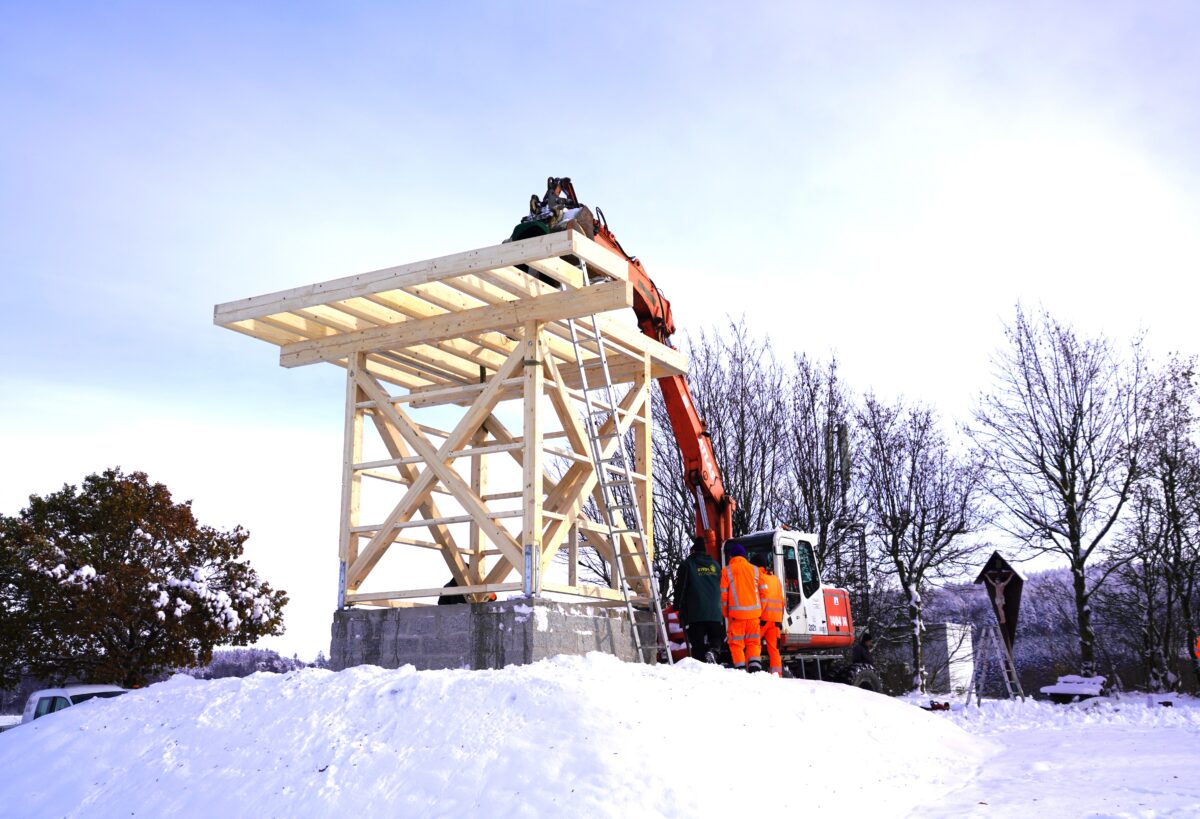 Gemeinsam heben Mitarbeiter der Firma Holzbau Riedl und Bauhof die neue 