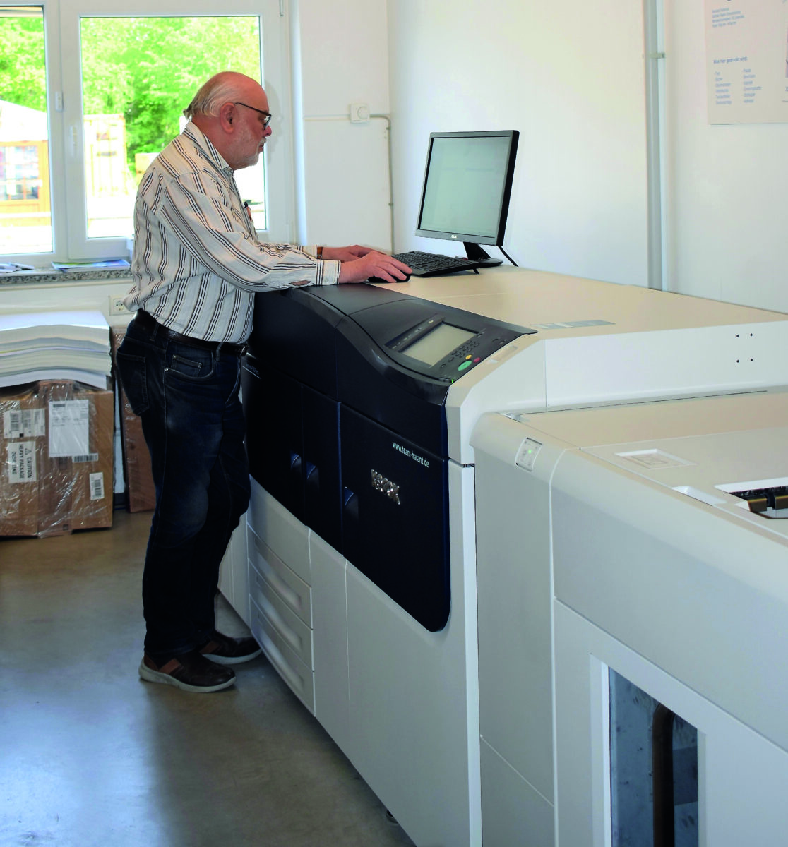 Seniorchef Johann Hutzler an seiner modernen Digitaldruckmaschine. Foto: Druckerei Hutzler