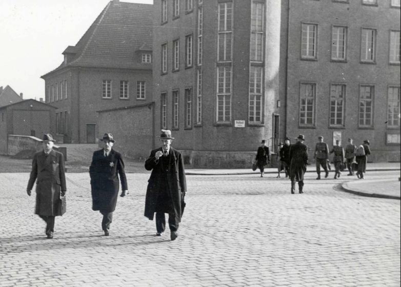 Otto Hausmann (Zweiter von links), begleitet von Sicherheitspolizisten, auf seinem letzten Weg in Weiden. Am 3. April 1942 wurde er mit seinen Söhnen und seiner Frau zum Bahnhof gebracht. Ein Deportationszug brachte sie in das Ghetto Piaski. Foto: Stadtarchiv  Weiden