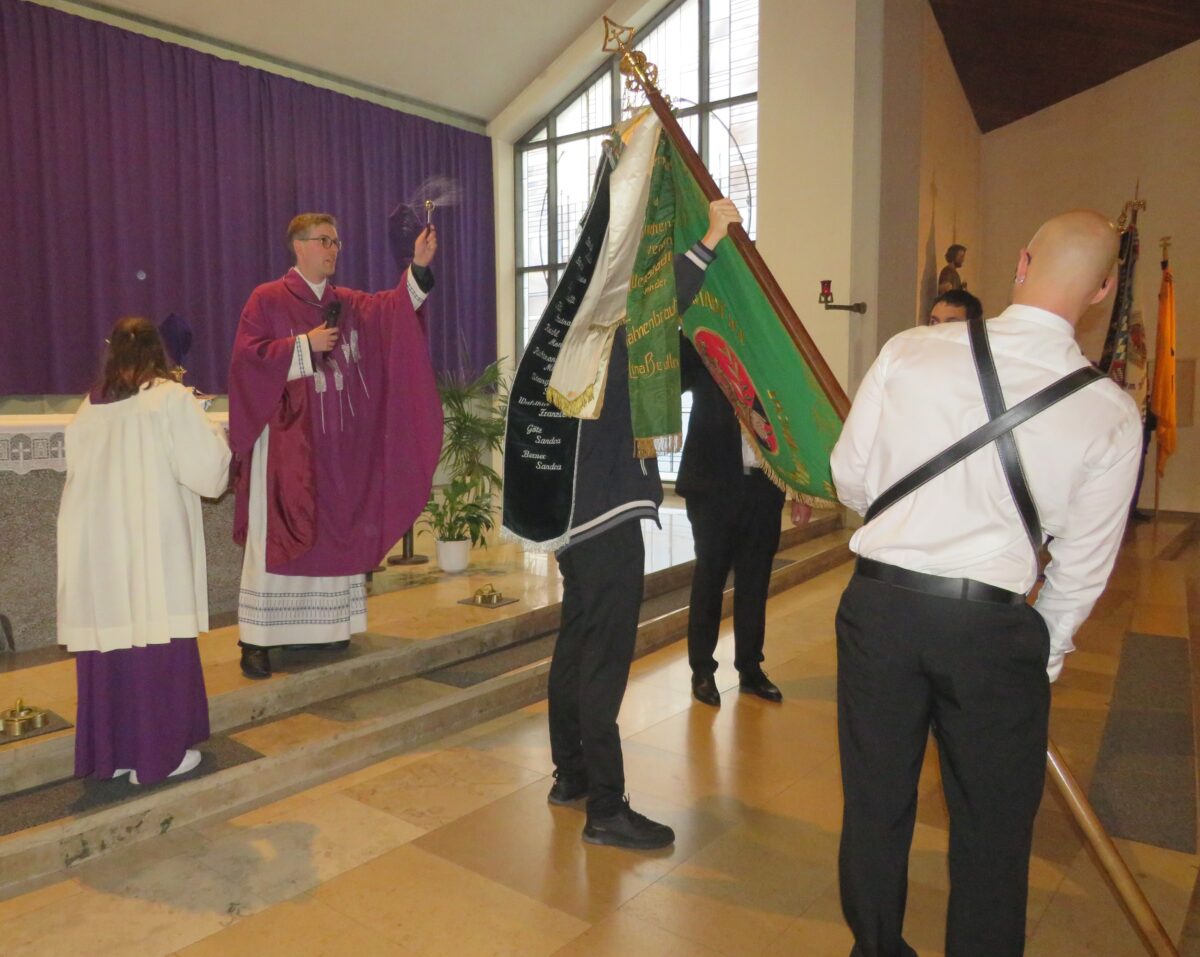 Die Fahne wird von Pfarrer Thomas Kopp gesegnet. Foto: Johann Adam